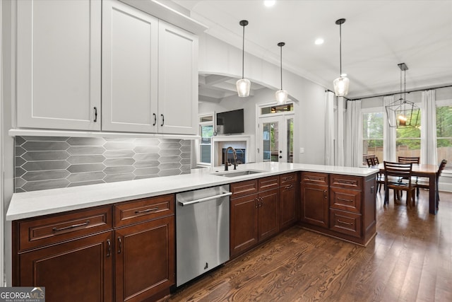 3668 Spring St, Chamblee, GA 30341 - kitchen featuring stainless steel dishwasher, light countertops, backsplash, dark wood-style flooring, and pendant lighting