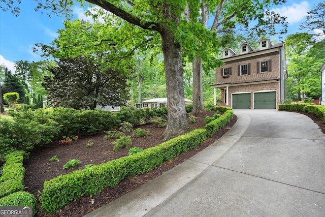 view of front of home with brick siding, an attached garage, and concrete driveway