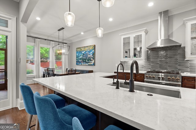 3668 Spring St, Chamblee, GA 30341 - kitchen featuring wall chimney exhaust hood, stainless steel range, a kitchen bar, light stone counters, and ornamental molding