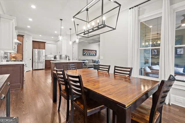 dining area featuring recessed lighting, ornamental molding, dark wood finished floors, and a notable chandelier