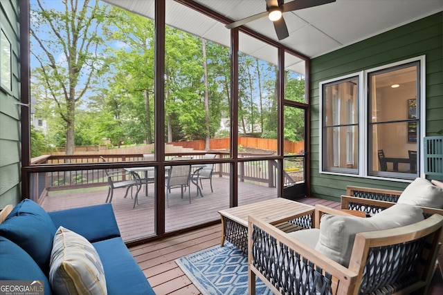 sunroom featuring outdoor dining space, ceiling fan, and outdoor lounge area