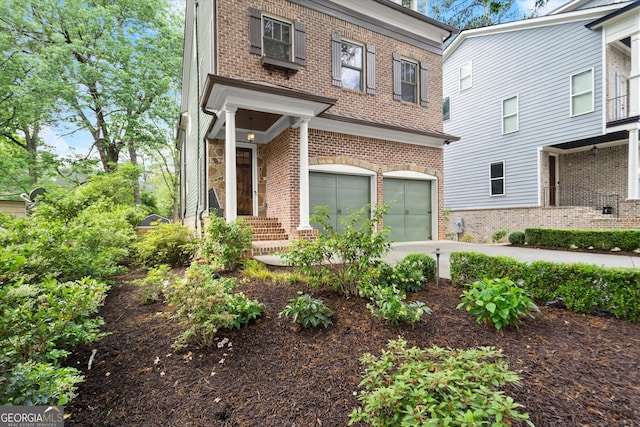 view of front facade with an attached garage, concrete driveway, and brick siding