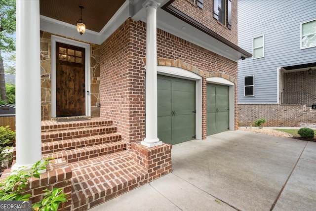 doorway to property with brick siding, driveway, and a garage