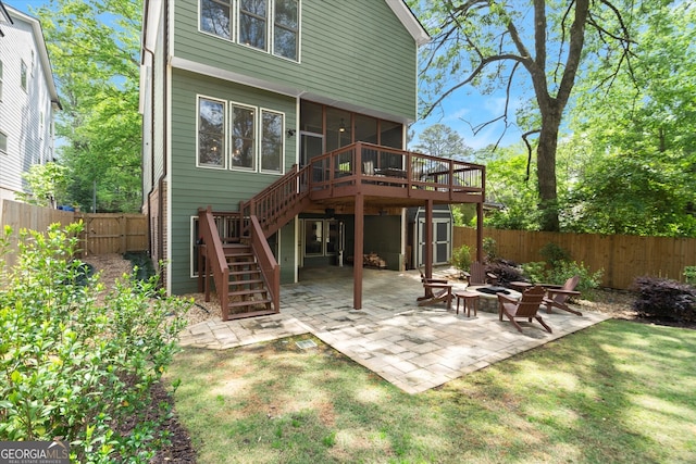 back of property with stairs, an outdoor fire pit, a deck, a fenced backyard, and a patio