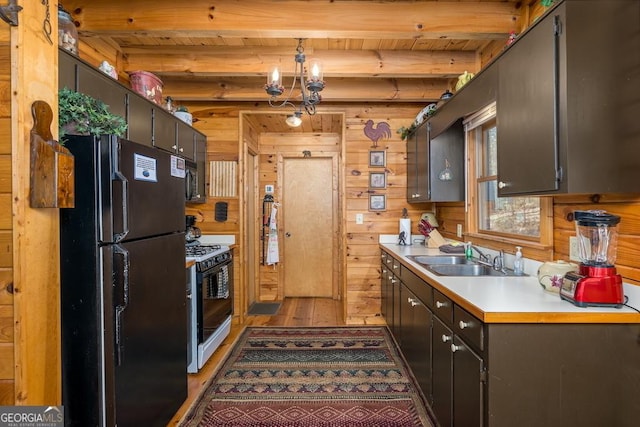 191 Mountain View Rd, Ellijay, GA 30540 - kitchen with freestanding refrigerator, white range with gas cooktop, a sink, light wood-style flooring, and wood walls