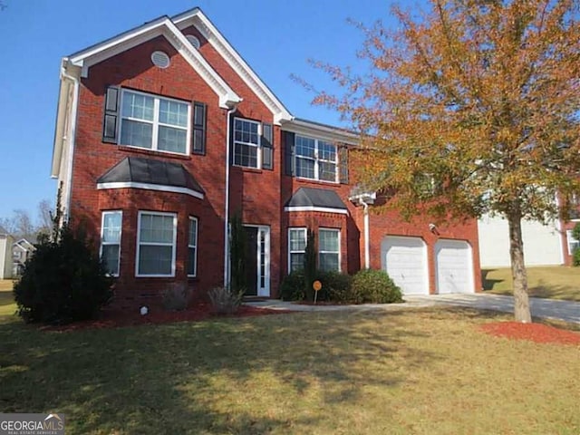view of front facade with a garage, brick siding, a front yard, and concrete driveway