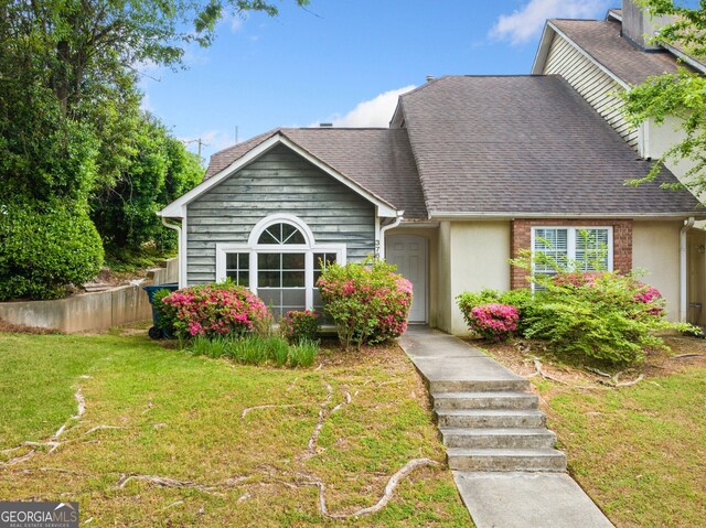 3765 Windsor Cir, Clarkston, GA 30021 - view of front of home with stucco siding, roof with shingles, a chimney, and a front lawn