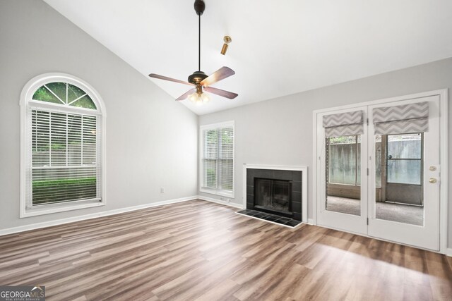 3765 Windsor Cir, Clarkston, GA 30021 - unfurnished living room with a tile fireplace, vaulted ceiling, wood finished floors, and baseboards