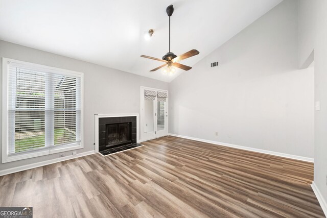 3765 Windsor Cir, Clarkston, GA 30021 - unfurnished living room featuring visible vents, baseboards, wood finished floors, a tiled fireplace, and a ceiling fan
