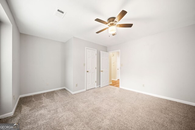 3765 Windsor Cir, Clarkston, GA 30021 - unfurnished bedroom featuring light colored carpet, visible vents, ceiling fan, and baseboards