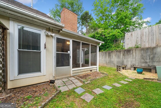 3765 Windsor Cir, Clarkston, GA 30021 - back of house with a lawn, a chimney, a fenced backyard, and a sunroom