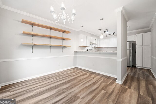 3765 Windsor Cir, Clarkston, GA 30021 - kitchen with a chandelier, light countertops, dark wood-style floors, freestanding refrigerator, and baseboards