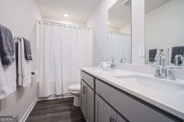 full bathroom with a sink, baseboards, toilet, and wood finished floors