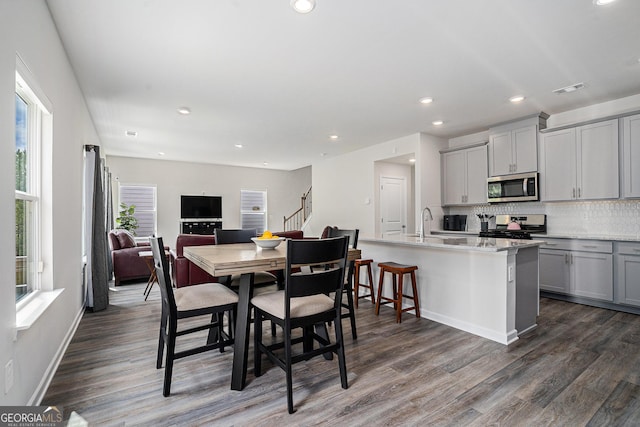 dining space with dark wood-style flooring, visible vents, recessed lighting, and stairway
