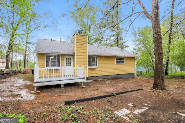 rear view of house featuring roof with shingles, a chimney, crawl space, and a wooden deck