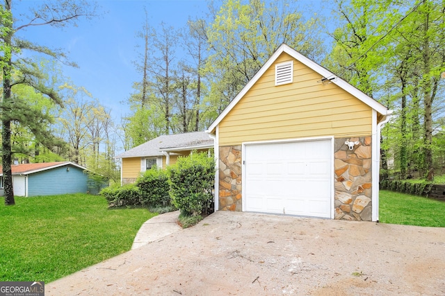 view of front of home featuring a garage, concrete driveway, a front yard, and stone siding