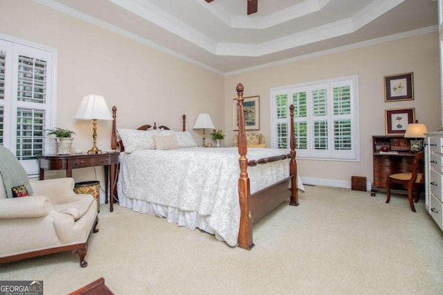 carpeted bedroom with a ceiling fan, baseboards, ornamental molding, and a raised ceiling