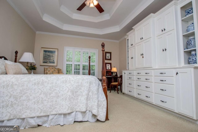 bedroom with light colored carpet, a ceiling fan, crown molding, and a tray ceiling