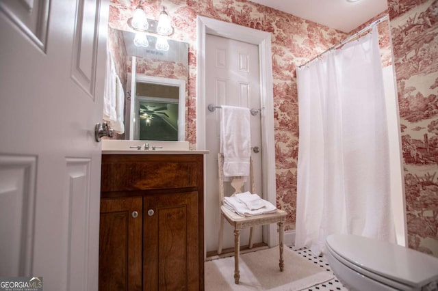 bathroom with vanity, toilet, a shower with curtain, and wallpapered walls