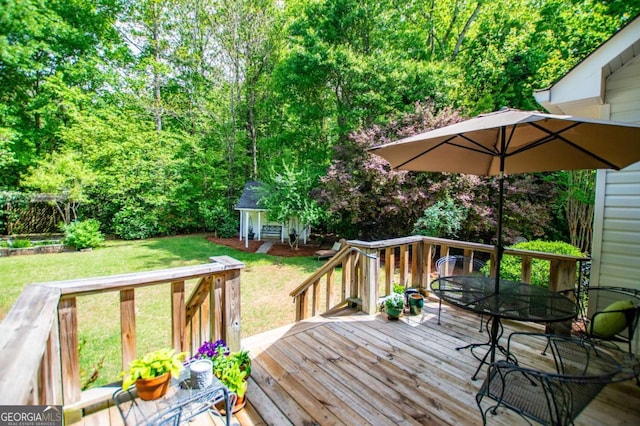 wooden deck featuring outdoor dining area, an outdoor structure, and a yard