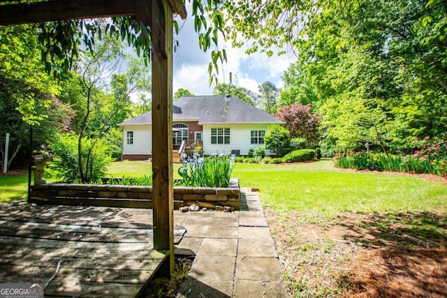 back of property featuring a lawn and a patio area