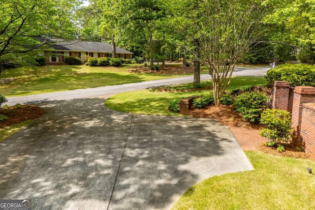 surrounding community with a lawn and driveway