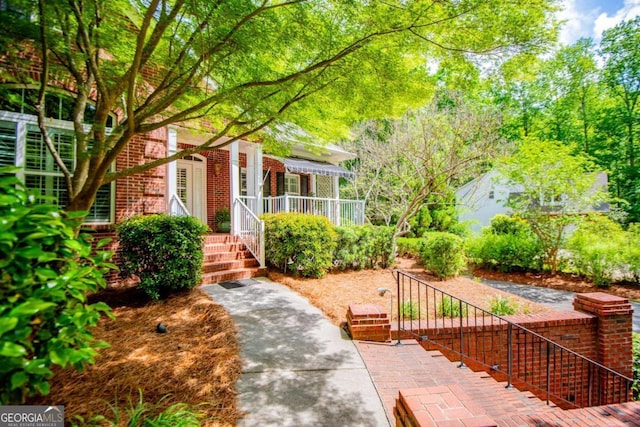 property entrance featuring covered porch and brick siding