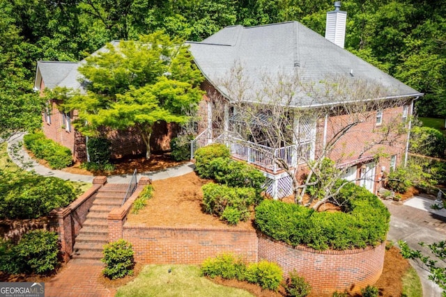 view of front of home featuring stairs, a chimney, and an attached garage