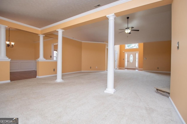 unfurnished living room with carpet floors, decorative columns, ornamental molding, visible vents, and a ceiling fan