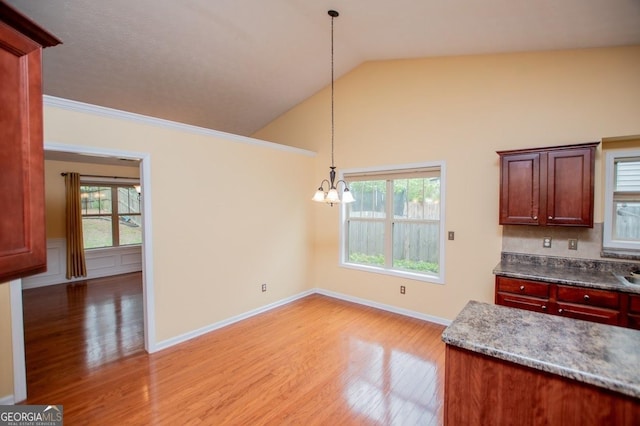 kitchen featuring light wood finished floors, an inviting chandelier, baseboards, pendant lighting, and lofted ceiling