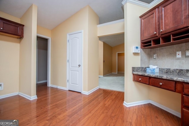 kitchen featuring baseboards, light wood-style flooring, and backsplash