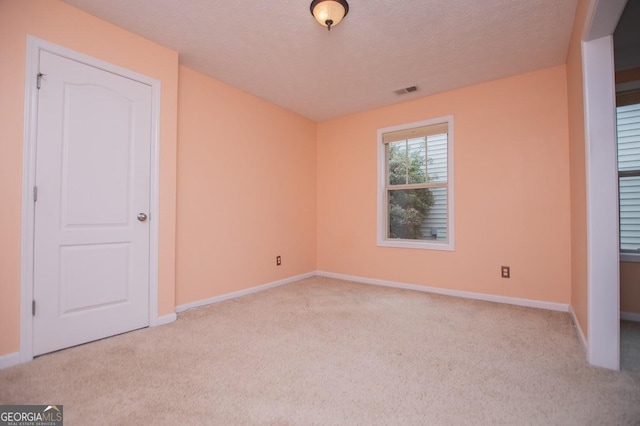 unfurnished bedroom featuring baseboards, visible vents, carpet floors, and a textured ceiling