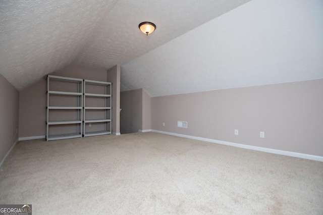 bonus room featuring lofted ceiling, carpet, and baseboards