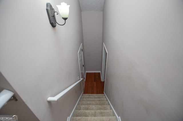 stairway with a textured ceiling