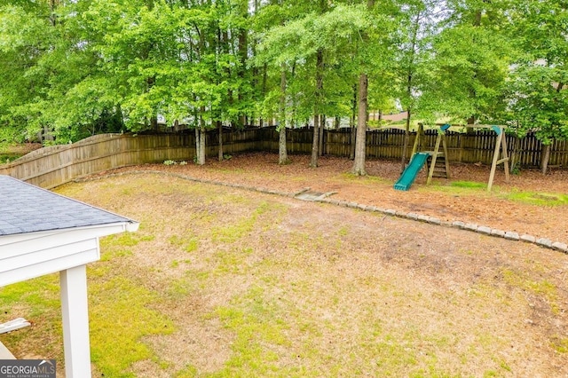 view of yard featuring a playground and a fenced backyard