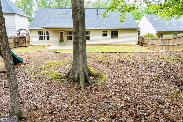 back of property with roof with shingles, a patio, and a fenced backyard