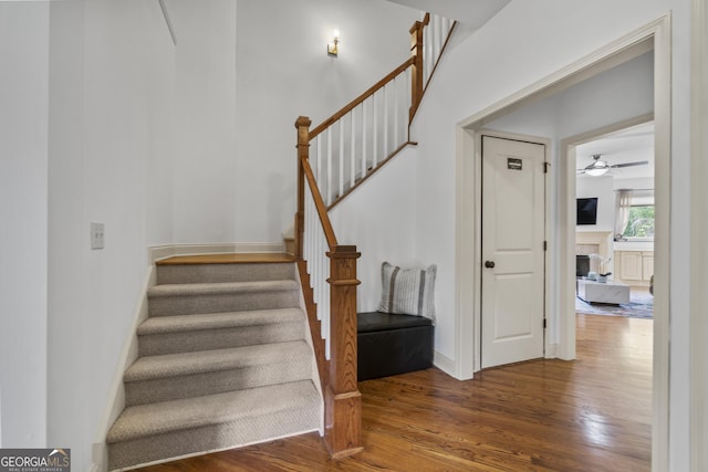 8275 Majors Ridge Way, Cumming, GA 30041 - staircase with wood finished floors, a fireplace, and ceiling fan