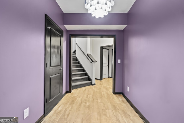 8275 Majors Ridge Way, Cumming, GA 30041 - hall with a chandelier, stairs, light wood-style floors, and baseboards