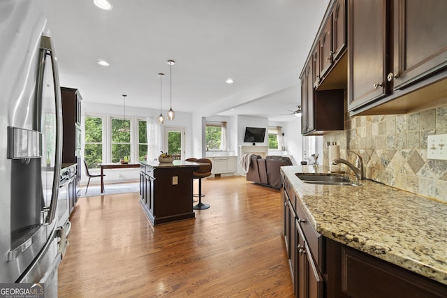 8275 Majors Ridge Way, Cumming, GA 30041 - kitchen featuring stainless steel fridge, a sink, dark brown cabinetry, open floor plan, and a breakfast bar