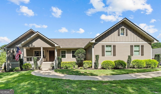 view of front facade with covered porch, board and batten siding, and a front yard