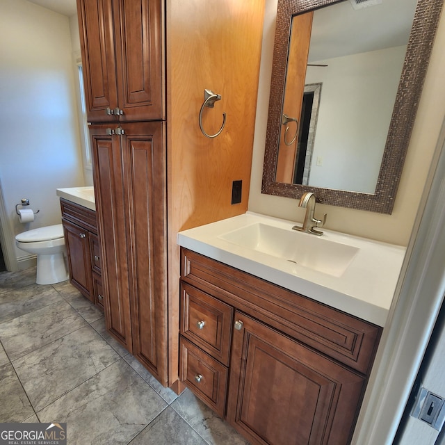 bathroom with toilet, visible vents, and vanity