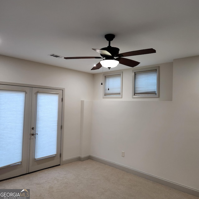 unfurnished room with light colored carpet, visible vents, baseboards, french doors, and a ceiling fan