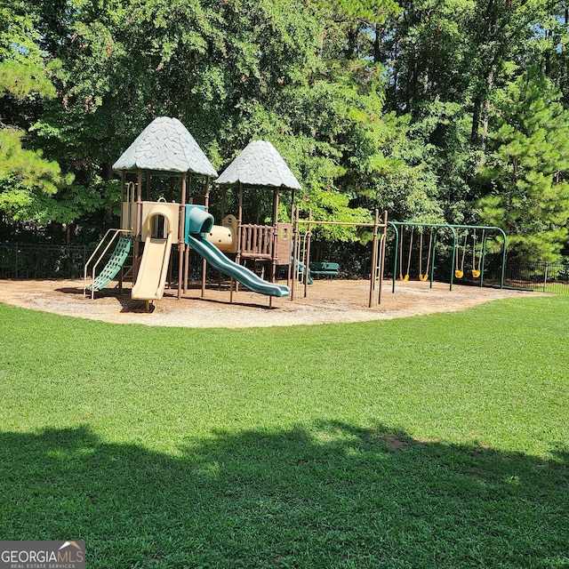 community play area featuring fence and a yard