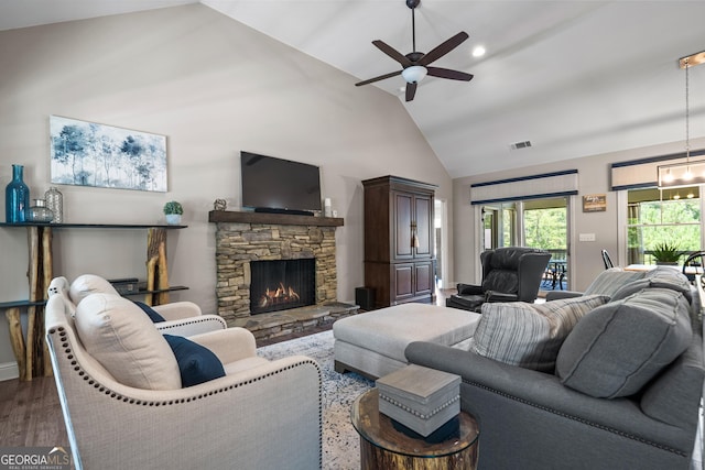 living room featuring a fireplace, ceiling fan, high vaulted ceiling, visible vents, and wood finished floors