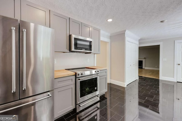 155 Hunters Pointe Dr, Athens, GA 30606 - kitchen with recessed lighting, ornamental molding, wooden counters, gray cabinetry, and appliances with stainless steel finishes