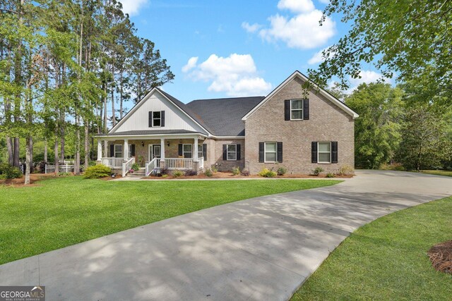 1703 Windsor Rd, Statesboro, GA 30461 - view of front facade with covered porch, concrete driveway, a front yard, brick siding, and a shingled roof