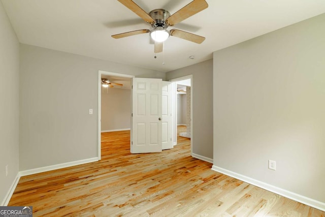 unfurnished bedroom featuring light wood-style floors, a ceiling fan, and baseboards