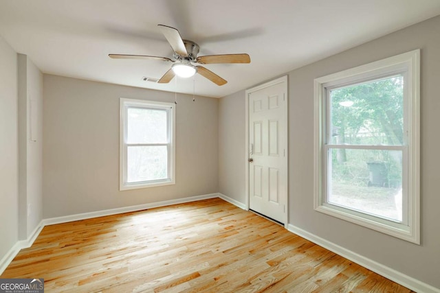 unfurnished bedroom with light wood finished floors, visible vents, multiple windows, and baseboards