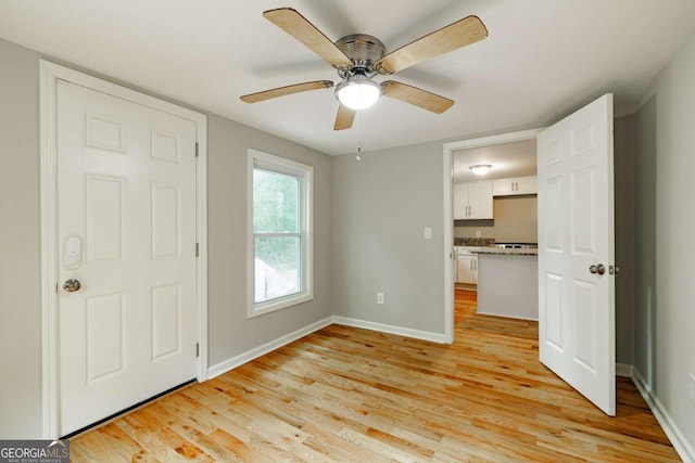unfurnished bedroom featuring light wood finished floors, ceiling fan, and baseboards