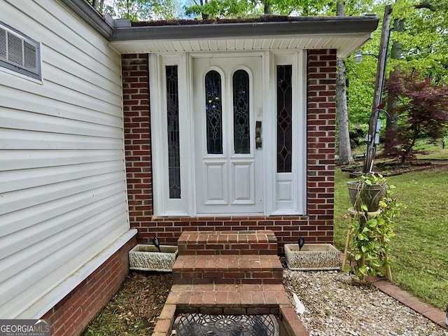 doorway to property with brick siding